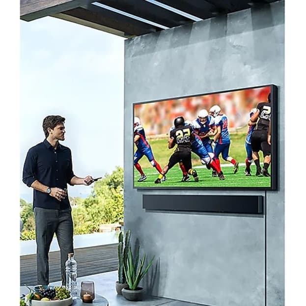 Samsung 65-inch Terrace QLED outdoor TV mounted on a patio wall